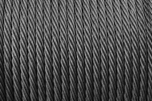 Steel rope is on a winch, close up, abstract industrial background texture. Black and white photo
