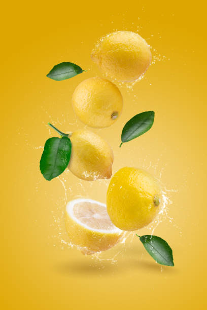 istock Water Splashing yellow lemon fruit on a yellow background. 1474103366