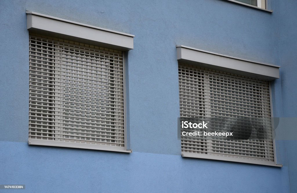 The rolling grille consists of a steel or aluminum armor that is wound on a shaft located above the opening. The shaft can be covered with an aluminum cover. a quick run down when going on vacation The rolling grille consists of a steel or aluminum armor that is wound on a shaft located above the opening. The shaft can be covered with an aluminum cover. a quick run down when going on vacation, screening, shaft, blinds window City Stock Photo