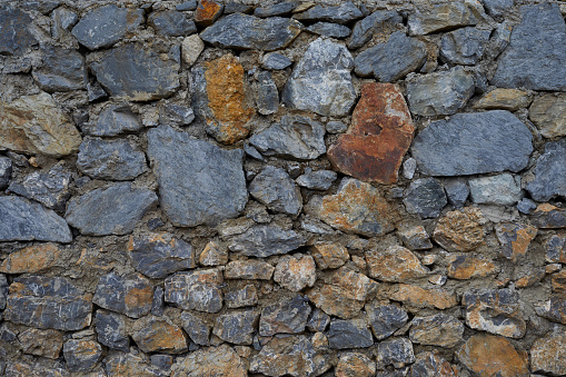 zoom view of a gray and copper color stones creating a retaining wall