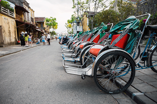 empty bike taxies parking in a row on street in ancient town Hoi An, vietnam