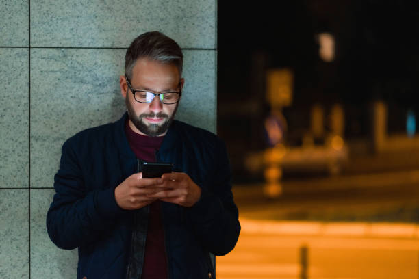 istock Using a smartphone in the city at night 1474106091