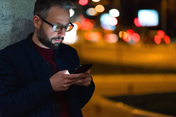 istock Using a smartphone in the city at night 1474106157