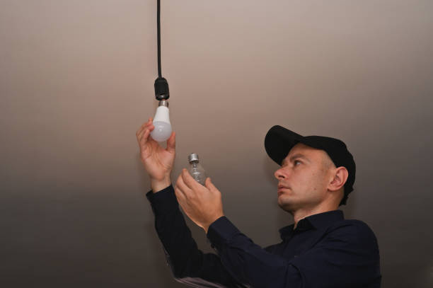 istock a man changes an incandescent lamp to an LED lamp. 1474106352