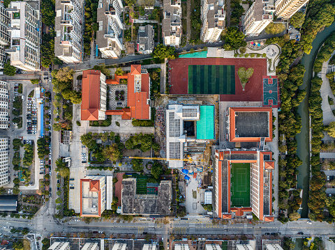 Aerial view of urban housing, schools, playgrounds, and green plants