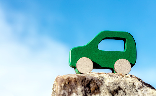 Green electric car background against blue sky environment and alternative energy concept