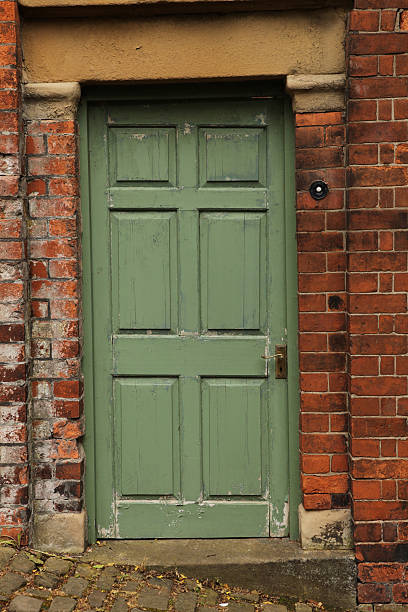istock Old green panelled door and brickwork. 147411463