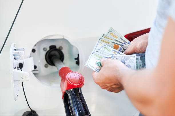 istock Man counting money he need to spend on fuel. 1474120322