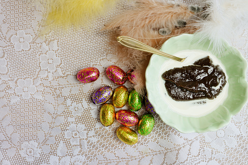 Malted rye and Easter chocolate Eggs on table in Finland,  decorated willow branch with colorful feathers