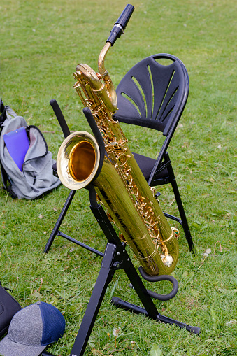 One yellow sax on the green grass. Musical sax is waiting for its musician. Musical repetition in the wild