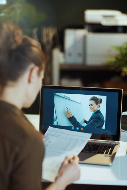 istock Seen from behind modern female with documents having video call 1474124195