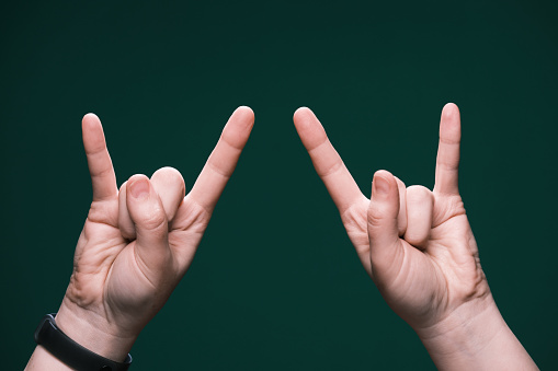 Human hand is making devil's horns gesture