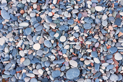 Sea pebbles of various shapes and colors on the shore. Close up, high resolution and very detailed photo (natural stone background)