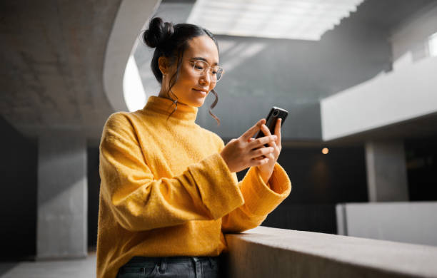 istock Woman, phone and texting in office building, thinking and calm while on internet, search and reading. Asian, girl and business entrepreneur with smartphone for research, office space or idea in Japan 1474125904