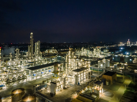 Aerial view of lighting chemical plant equipment and buildings at night