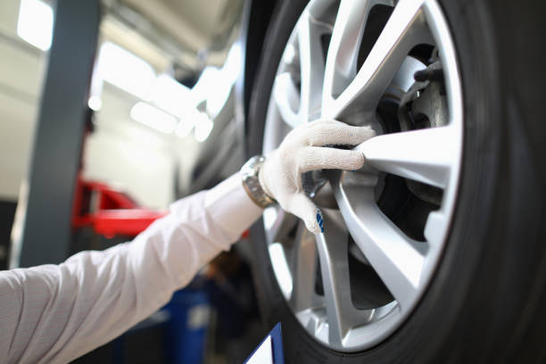 istock Mechanic changes car wheel in auto repair shop 1474128034