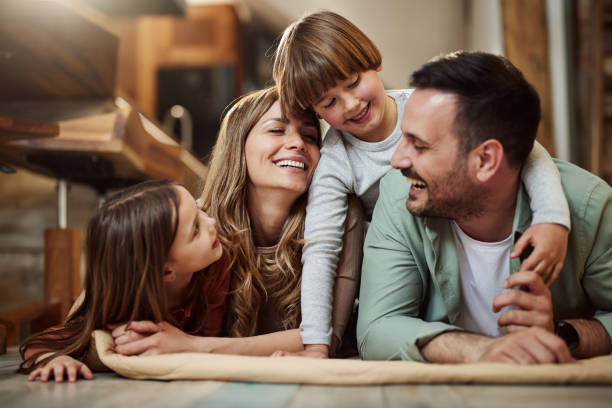 Giovane famiglia felice che parla sulla coperta a casa. - foto stock