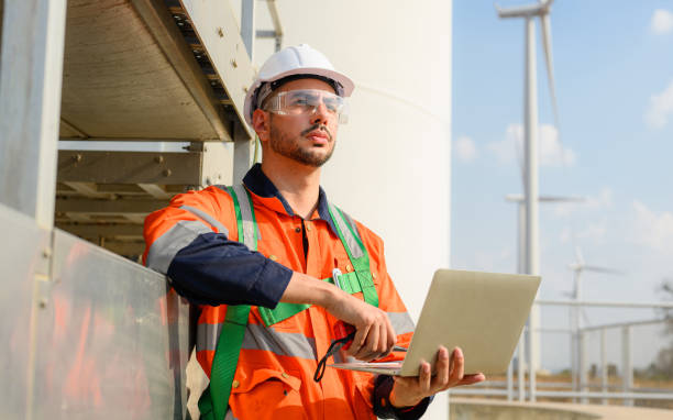 istock Professional engineer technician team working at wind turbine farm field 1474131773