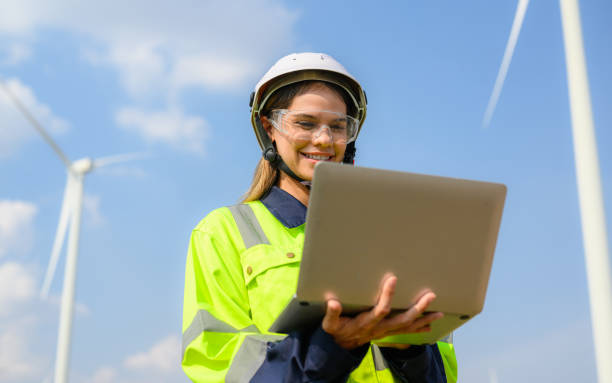 istock Happy female engineer technician working outdoor at wind turbine field 1474132921