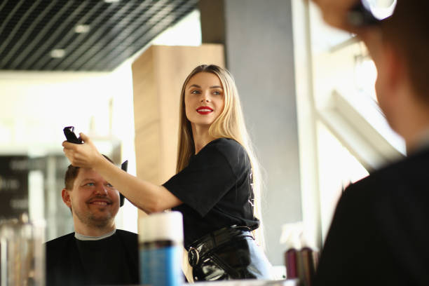 istock Master barber cuts young man with clipper in beauty salon 1474133143