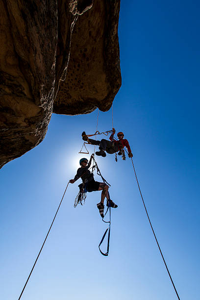 Climbing team struggles to the summit. stock photo
