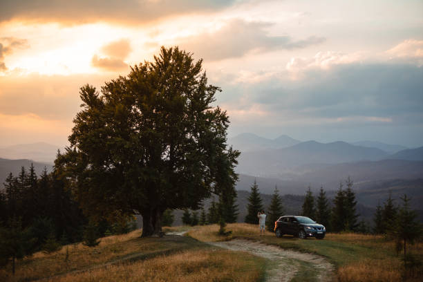 istock Man near car. Sunset in the mountains 1474135906