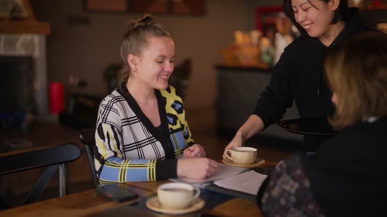 Two businesswomen meeting in cafe and talking with each other