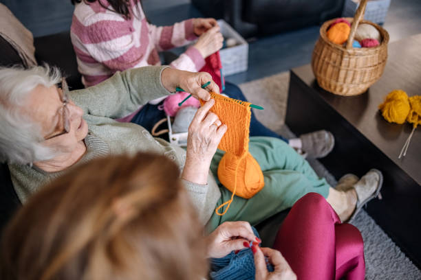 istock Senior woman teaching her daughters how to knit 1474136600