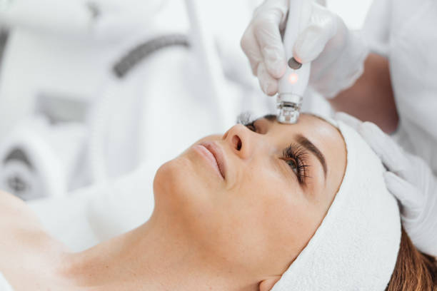 lifting de la peau du visage par radiofréquence. matériel cosmétologie rf procédure de levage et matériel massage facial. rajejeunissement, soins de la peau dans un salon de beauté. femme médecin cosmétologue et fille dans la clinique thermale. - head massage audio photos et images de collection