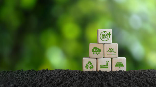 istock Net Zero and Carbon Neutral Concepts Net Zero Emissions Goals A climate-neutral long-term strategy Ready to put wooden blocks by hand with green net center icon and green icon on gray background. 1474142018