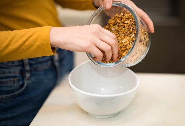 istock Unrecognizable lady making whole grain granola, closeup 1474142588