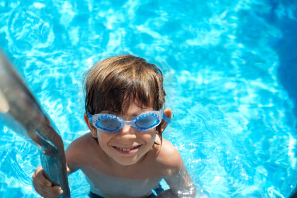 istock Boy on the pool ladder with aqua goggles 1474150808