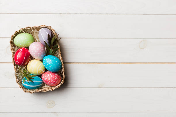 istock Multi colors Easter eggs in the woven basket on colored background . Pastel color Easter eggs. holiday concept with copy space 1474150933