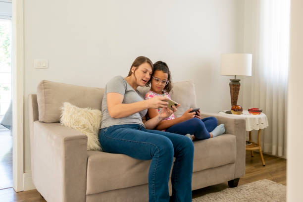 istock Mother and daughter using digital devices at home. 1474151355