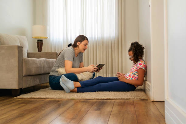 istock Mother and daughter using digital devices at home. 1474151525