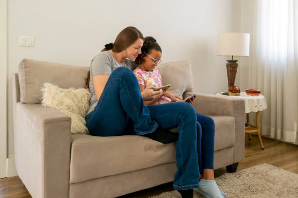 istock Mother and daughter using digital devices at home. 1474151839
