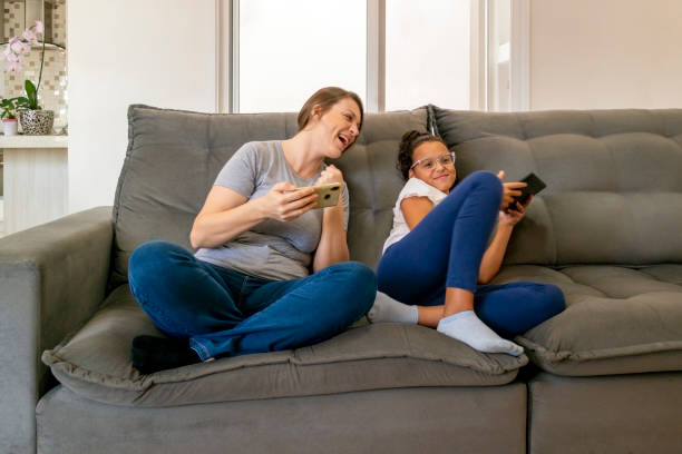 istock Mother and daughter using digital devices at home. 1474152014