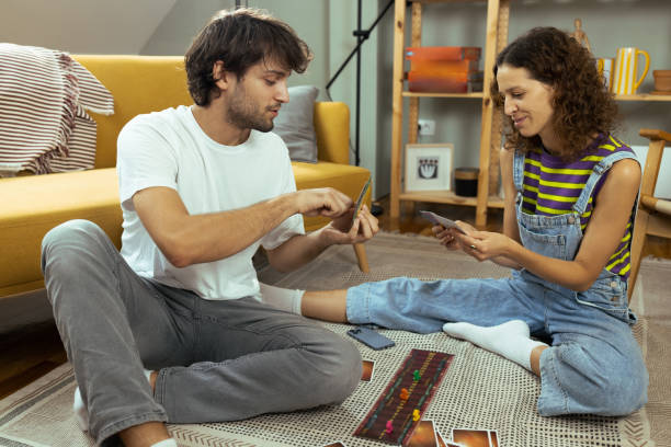 istock Young couple playing a board game at home 1474152051
