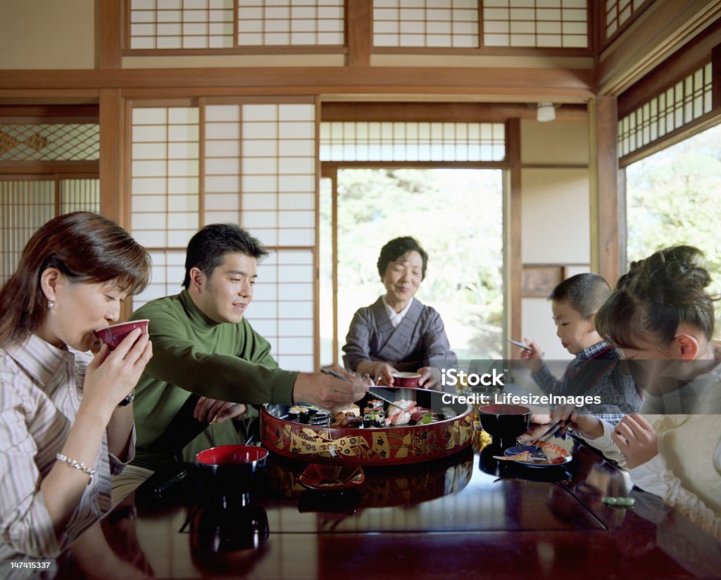 Une famille de trois générations à manger des sushis - Photo de Famille libre de droits