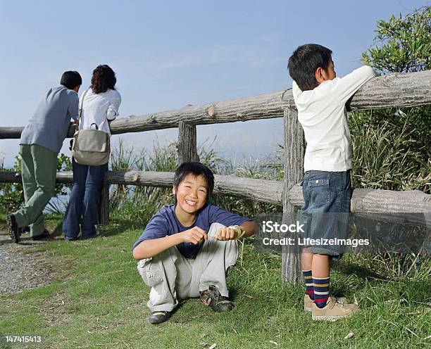 Parents And Two Sons Beside Wooden Fence Focus Stock Photo - Download Image Now