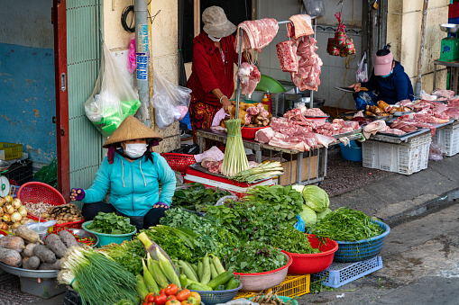 Kampot, Cambodia – August 07, 2019: A woman trader selling vegetables and fruit at the  A woman trader selling vegetables and fruit at the Kampot fresh market