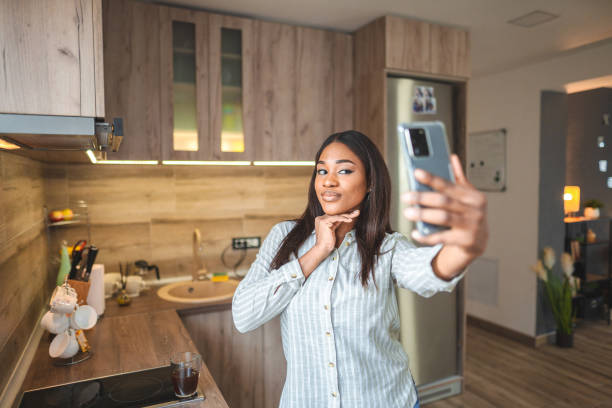 istock Young black woman taking selfies by the kitchen window 1474157181