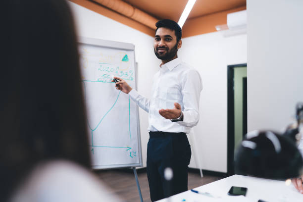 istock Ethnic male entrepreneur explaining presentation in office 1474158504