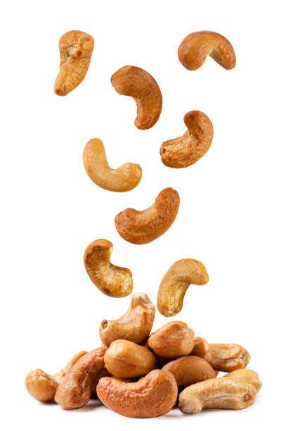 istock Roasted cashew nuts fall on a pile on a white background. Isolated 1474162822
