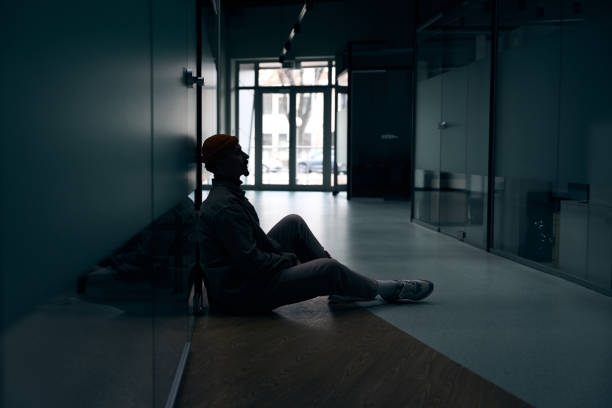 istock Depressed company employee seated alone in dark corridor 1474164575