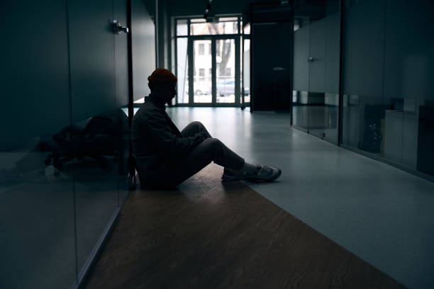 istock Despondent corporate worker seated in office corridor 1474164579