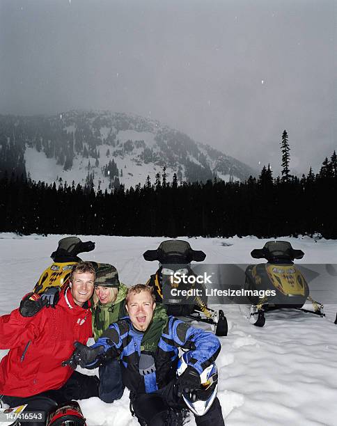 Photo libre de droit de Deux Hommes Et Une Femme Assis Sur La Neige En Motoneige Portrait banque d'images et plus d'images libres de droit de 20-24 ans