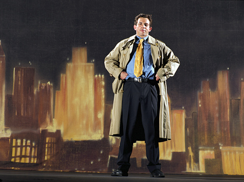 Man wearing suit and trenchcoat, painted skyline in background