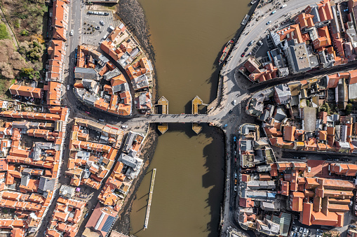 An aerial map style view directly above the swing bridge joining the seaside town of Whitby over the estuary of the river Esk in North Yorkshire