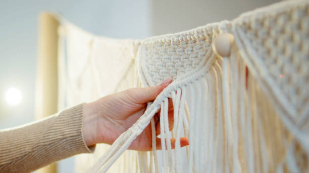 istock Female hands weave mandalas of white strings.( close-up). 1474173782